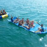 a group of people riding on the back of a boat in the water