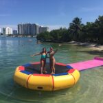 a little girl riding on the back of a boat in the water